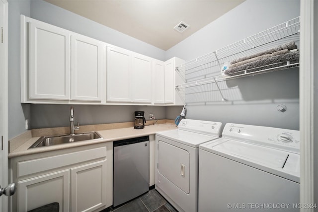 washroom featuring washing machine and clothes dryer, cabinets, and sink