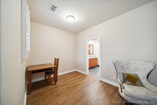 home office with wood-type flooring and sink