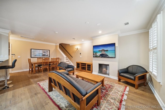 living room featuring light wood-type flooring and ornamental molding