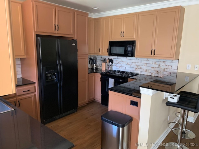 kitchen featuring light brown cabinets, dark wood-type flooring, black appliances, ornamental molding, and tasteful backsplash