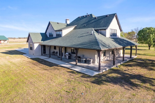 rear view of property with a lawn, cooling unit, and a patio area