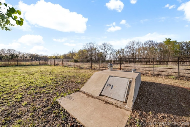 entry to storm shelter with a yard and a rural view