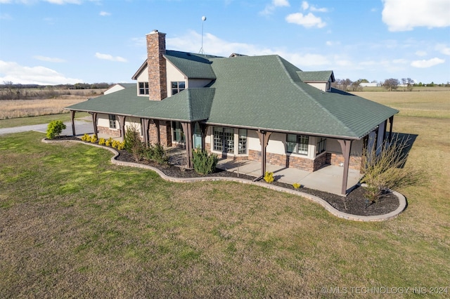 rear view of house featuring a patio area and a yard