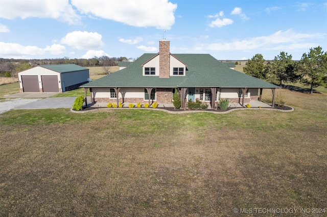 view of front of house with a porch, an outbuilding, a front yard, and a garage