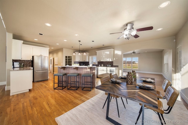 dining area with ceiling fan, sink, and light hardwood / wood-style flooring