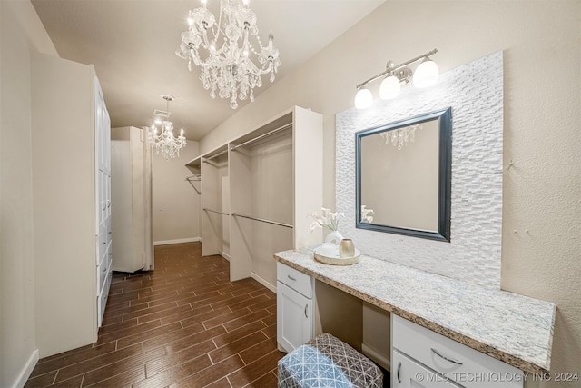 walk in closet featuring a chandelier and dark hardwood / wood-style flooring