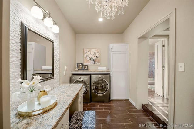 bathroom featuring washer and clothes dryer, a notable chandelier, and vanity