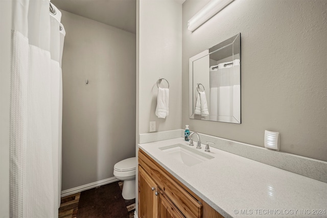 bathroom with vanity, hardwood / wood-style flooring, and toilet