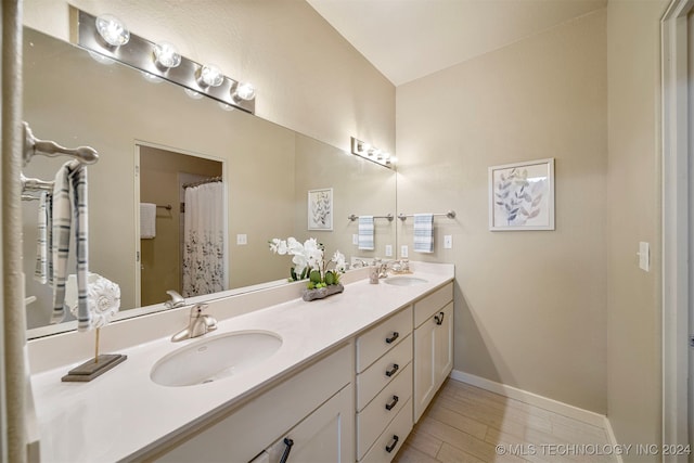 bathroom with hardwood / wood-style floors, vanity, and curtained shower