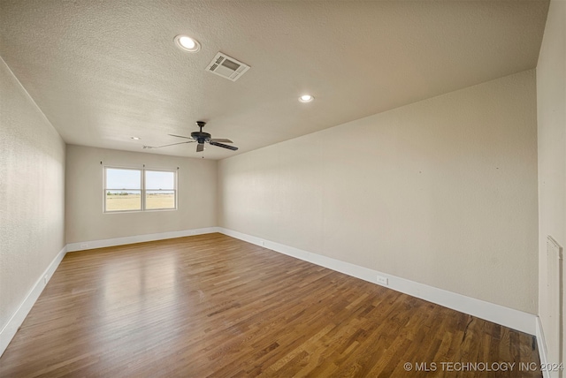 empty room with a textured ceiling, hardwood / wood-style flooring, and ceiling fan