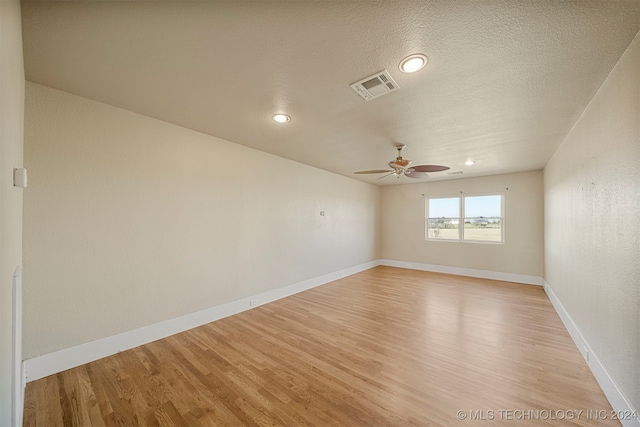 unfurnished room with ceiling fan, light hardwood / wood-style floors, and a textured ceiling