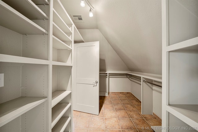 walk in closet featuring lofted ceiling and light tile patterned floors