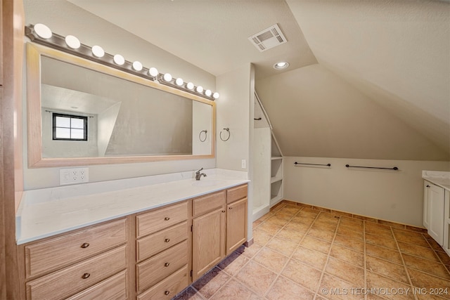 bathroom featuring tile patterned floors, vanity, and lofted ceiling