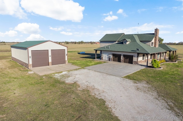 garage featuring a lawn and a rural view