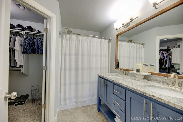 bathroom with a shower with curtain, vanity, tile patterned floors, and a textured ceiling