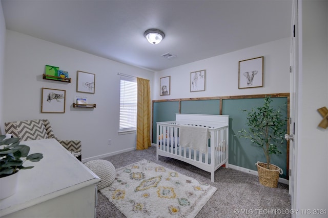 bedroom featuring a crib and carpet