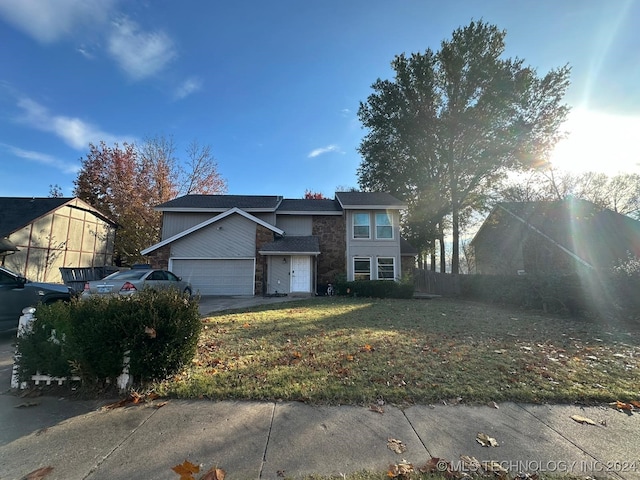 view of property featuring a front yard and a garage