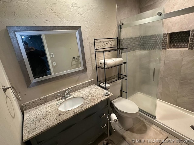 bathroom with vanity, toilet, and a shower with shower door