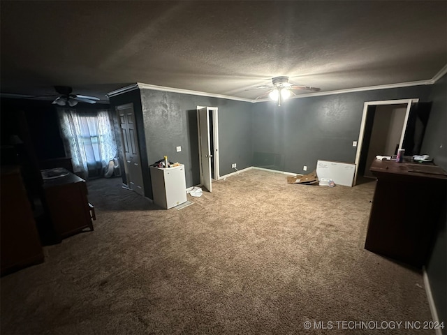 interior space featuring a textured ceiling, ceiling fan, dark carpet, and crown molding