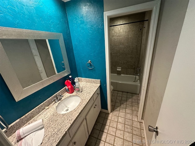 full bathroom featuring vanity, tiled shower / bath combo, and toilet