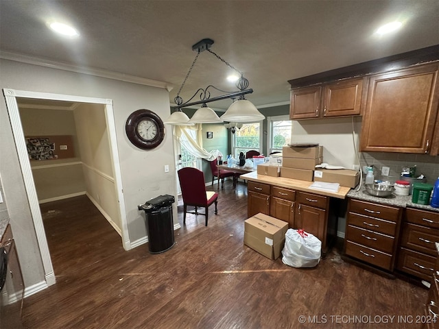 kitchen with pendant lighting, ornamental molding, dark wood-type flooring, and tasteful backsplash