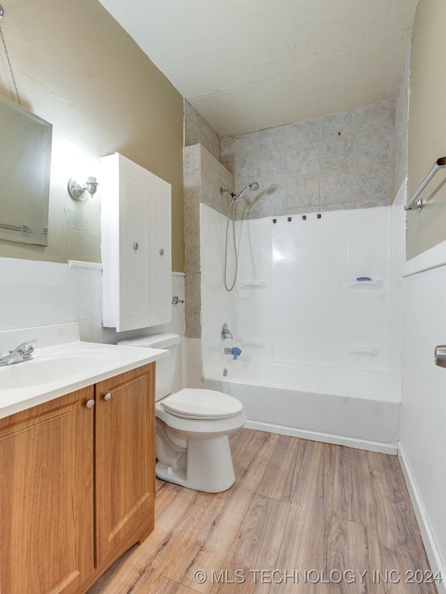 full bathroom featuring vanity, hardwood / wood-style flooring, toilet, and tiled shower / bath combo