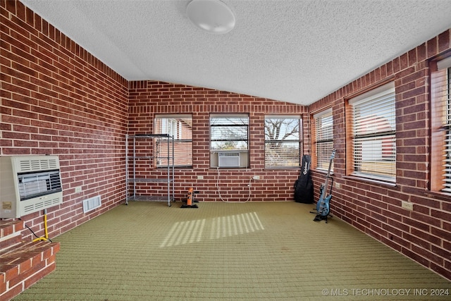 unfurnished sunroom with heating unit, cooling unit, and lofted ceiling