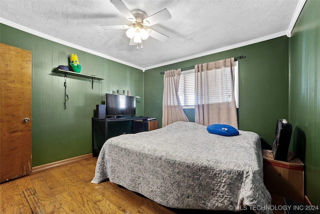 bedroom featuring hardwood / wood-style floors, a textured ceiling, ornamental molding, and ceiling fan