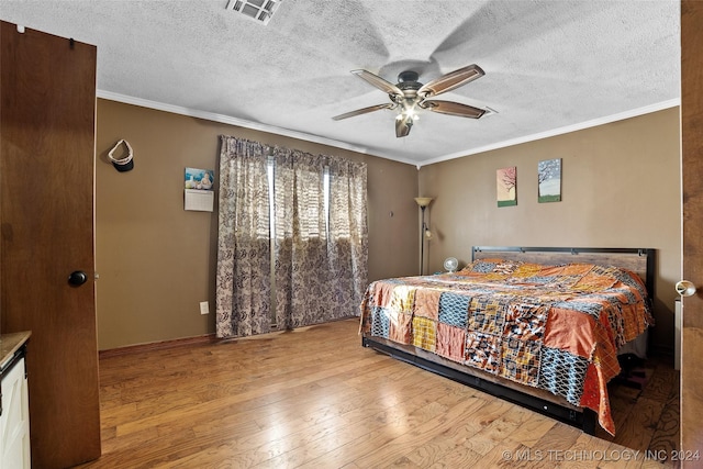 bedroom with crown molding, ceiling fan, a textured ceiling, and light wood-type flooring