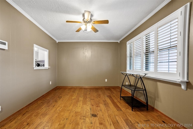 empty room featuring ornamental molding, a textured ceiling, ceiling fan, and light hardwood / wood-style flooring