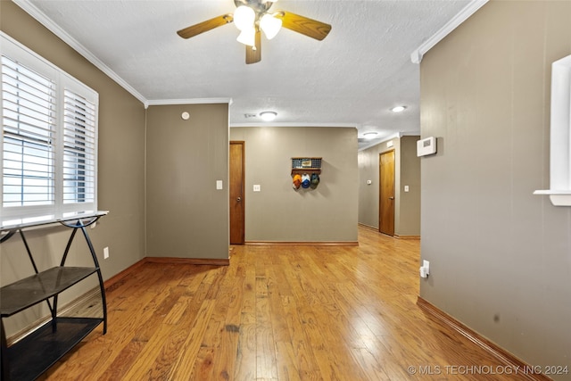 interior space with crown molding, ceiling fan, a textured ceiling, and light wood-type flooring