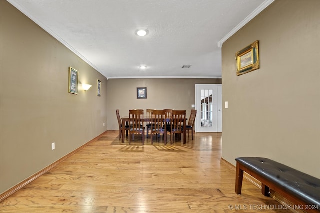 dining area featuring ornamental molding and light wood-type flooring