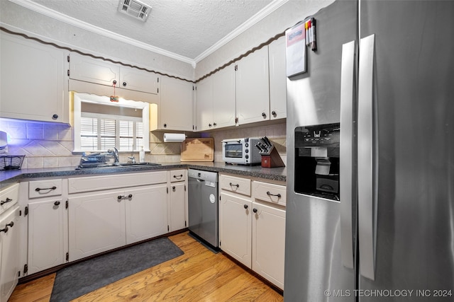 kitchen with stainless steel appliances, white cabinetry, a textured ceiling, and decorative backsplash