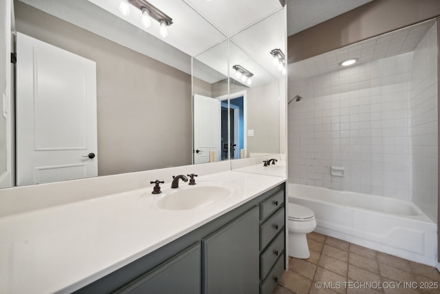 full bathroom with tile patterned floors, toilet, tiled shower / bath combo, and vanity