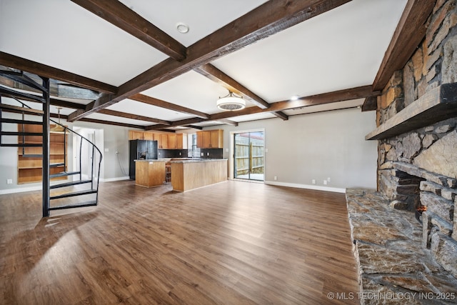 unfurnished living room with dark wood-type flooring and beamed ceiling