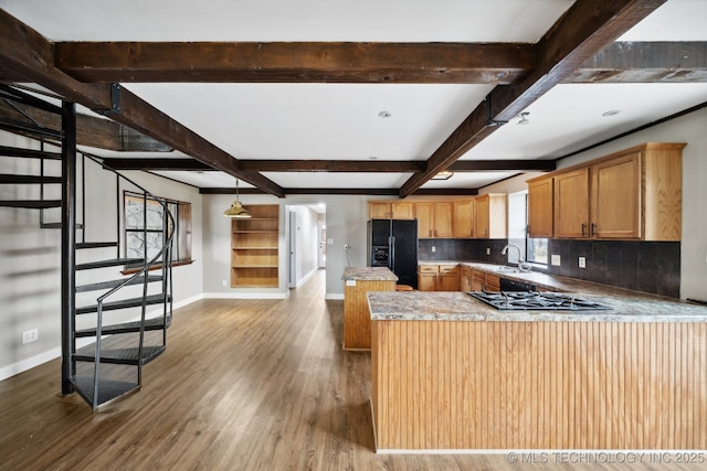 kitchen with wood-type flooring, black refrigerator with ice dispenser, kitchen peninsula, beamed ceiling, and decorative backsplash