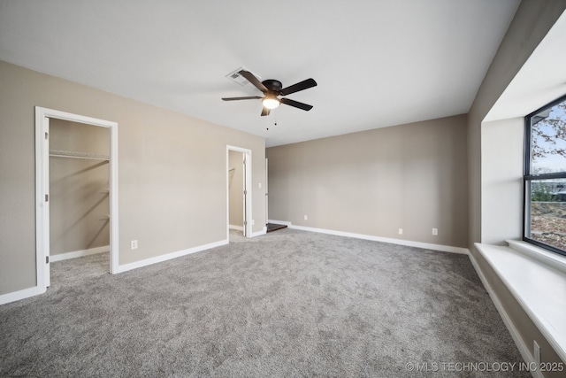 unfurnished bedroom featuring a spacious closet, carpet floors, and ceiling fan