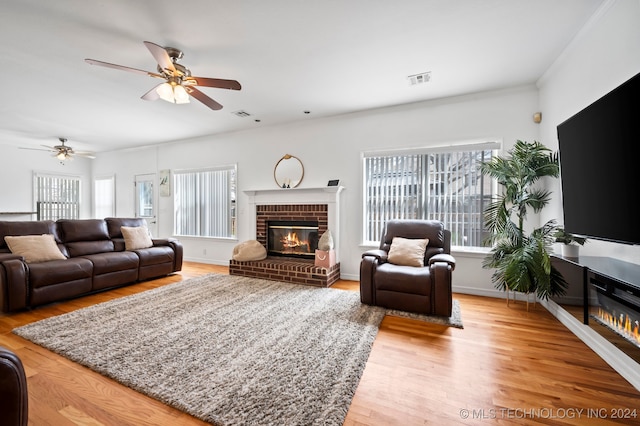 living room with a fireplace, ceiling fan, and hardwood / wood-style floors