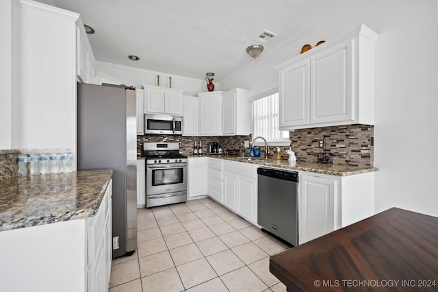 kitchen with white cabinets, decorative backsplash, and stainless steel appliances