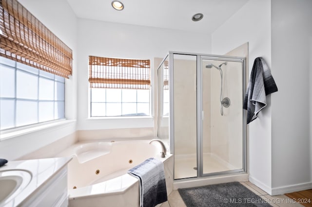 bathroom with tile patterned flooring, vanity, and shower with separate bathtub