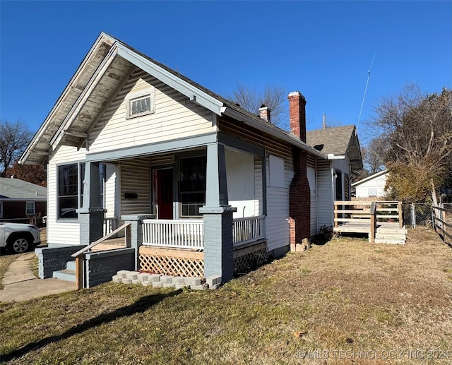 view of front of house with covered porch and a front lawn