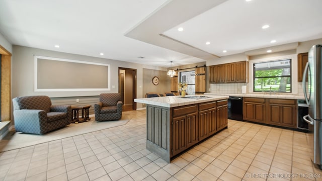 kitchen with decorative backsplash, stainless steel fridge, black dishwasher, tile counters, and a kitchen island