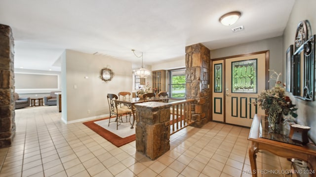 entryway with light tile patterned floors and a notable chandelier