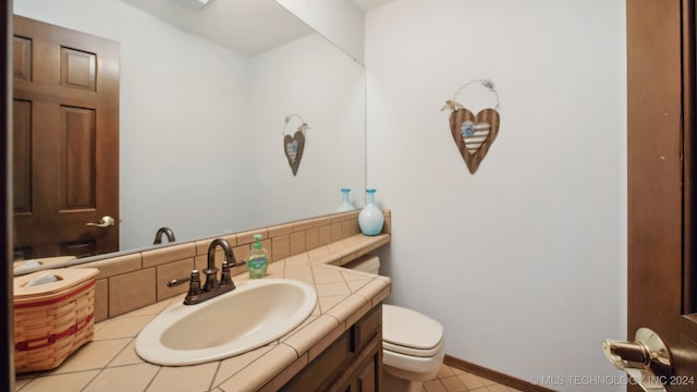 bathroom with tile patterned flooring, vanity, and toilet