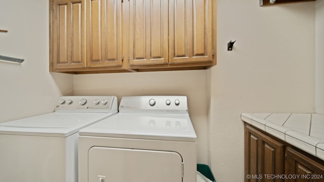 laundry area featuring cabinets and washing machine and dryer