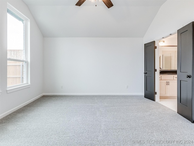 unfurnished bedroom with light colored carpet, multiple windows, lofted ceiling, and ceiling fan