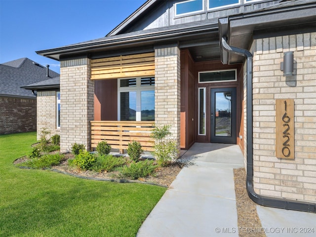 entrance to property featuring a yard