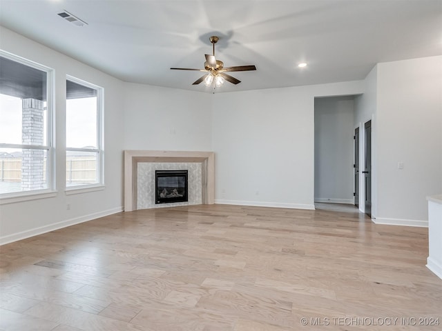 unfurnished living room with a fireplace, light hardwood / wood-style flooring, and ceiling fan