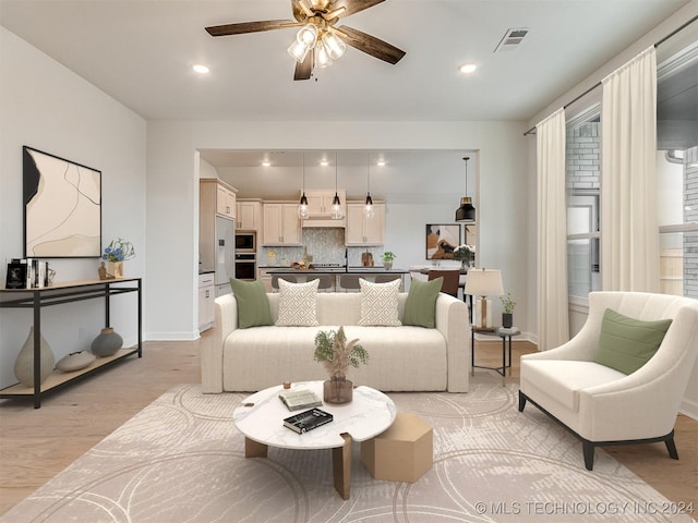 living room with light hardwood / wood-style flooring and ceiling fan