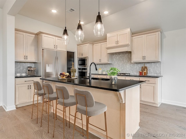 kitchen featuring decorative backsplash, sink, pendant lighting, built in appliances, and light hardwood / wood-style floors